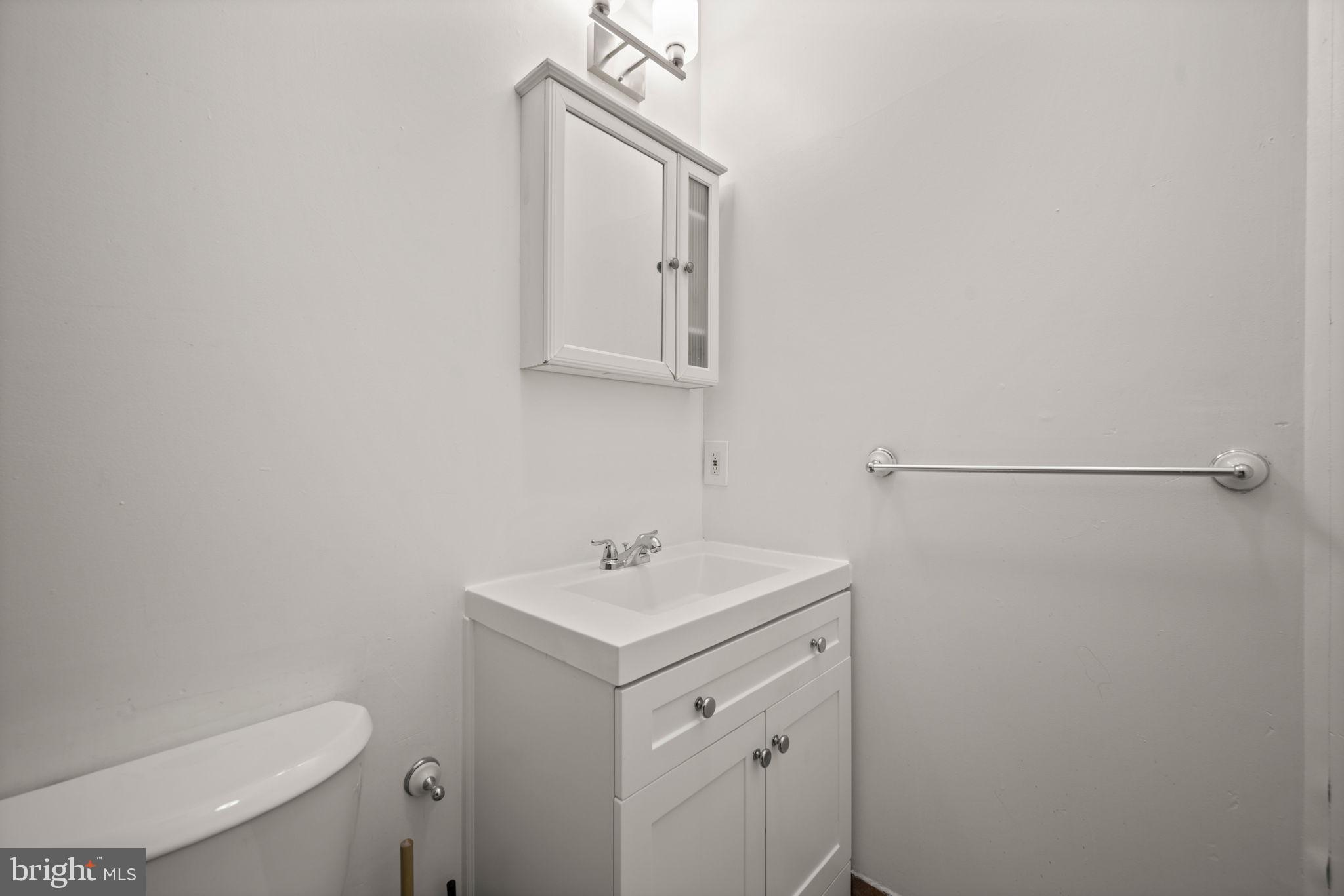 2422 Madison Avenue, Unit 1 Baltimore, MD 21217 - Photo 9 of 34 a bathroom with a toilet sink and mirror