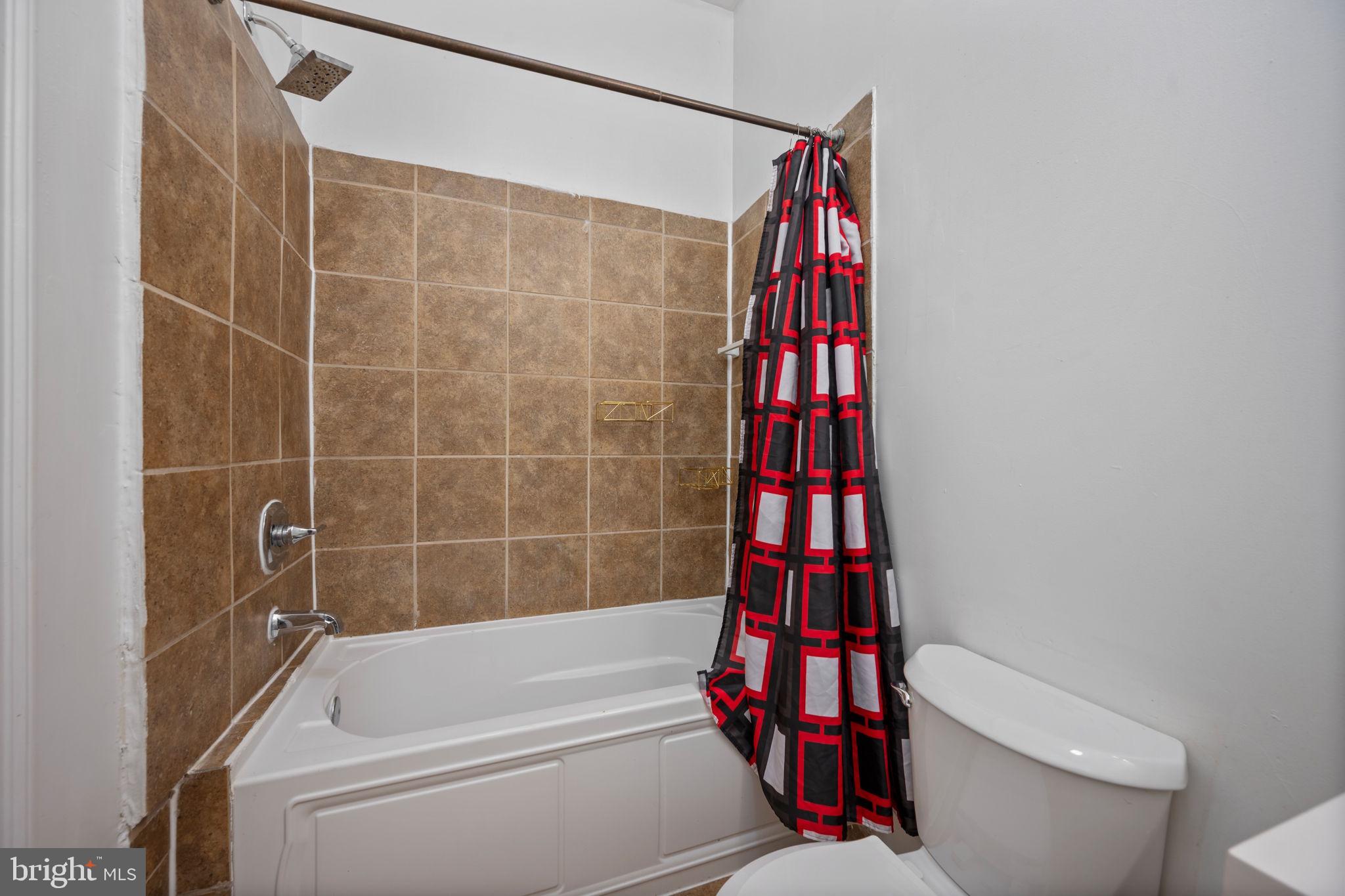 2422 Madison Avenue, Unit 1 Baltimore, MD 21217 - Photo 10 of 34 a bathroom with a bathtub and a toilet
