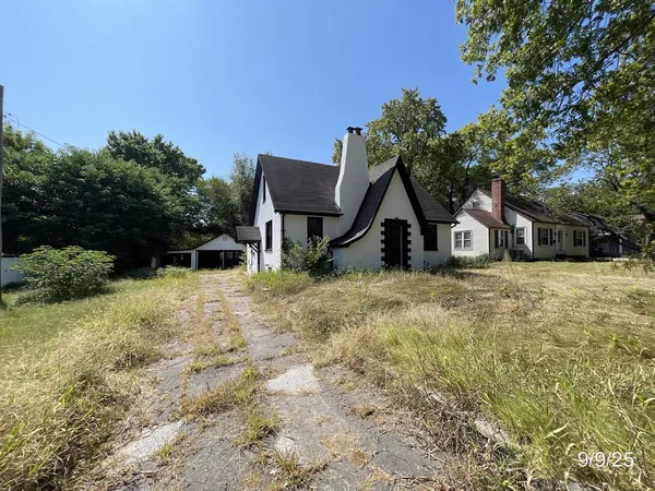 a view of house with backyard and trees