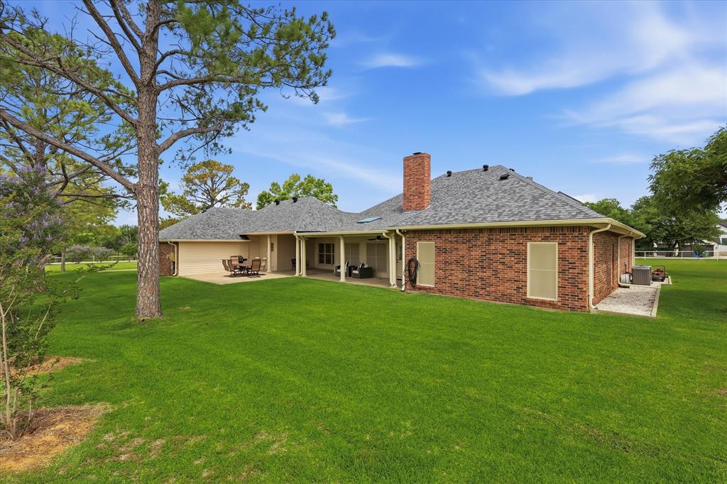 6955 Hawk Road Flower Mound, TX 75022 - Photo 33 of 40 Spacious backyard featuring a manicured lawn, an extended covered patio, and a separate open patio area