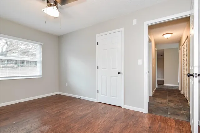 a view of a hallway with a window and wooden floor