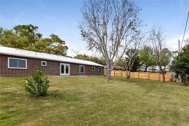 a view of a yard in front of a house with large trees