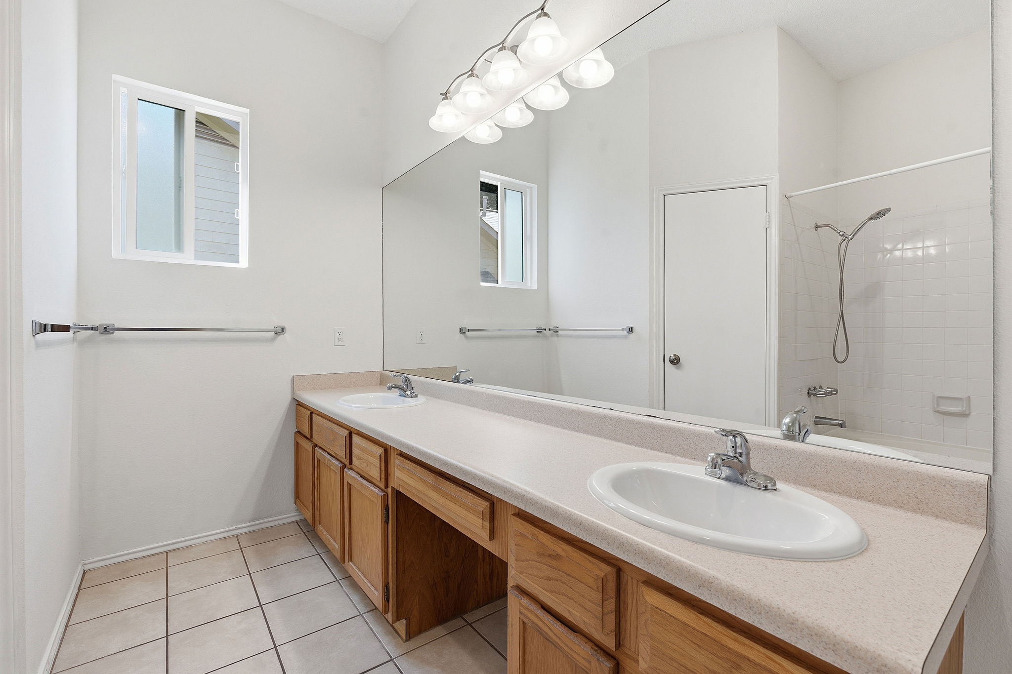 14818 Yellowleaf Trail Austin, TX 78728 - Photo 12 of 26 Bathroom featuring a dual vanity with light wood cabinetry, white oval sinks, and a full-width mirror