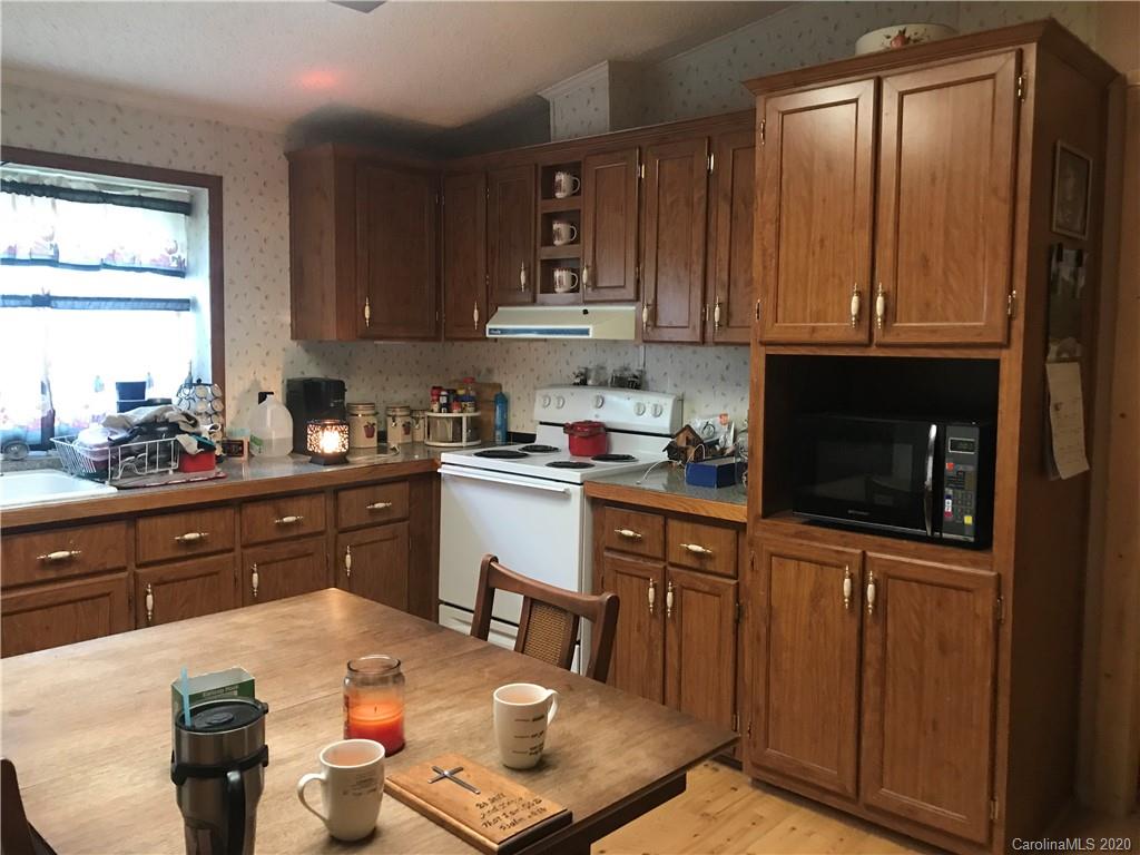 480 Hester Mill Road Rutherfordton, NC 28139 - Photo 24 of 38 a kitchen with granite countertop a sink dishwasher a stove and a refrigerator with wooden cabinets