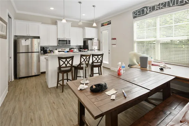 a kitchen with a table chairs refrigerator and microwave