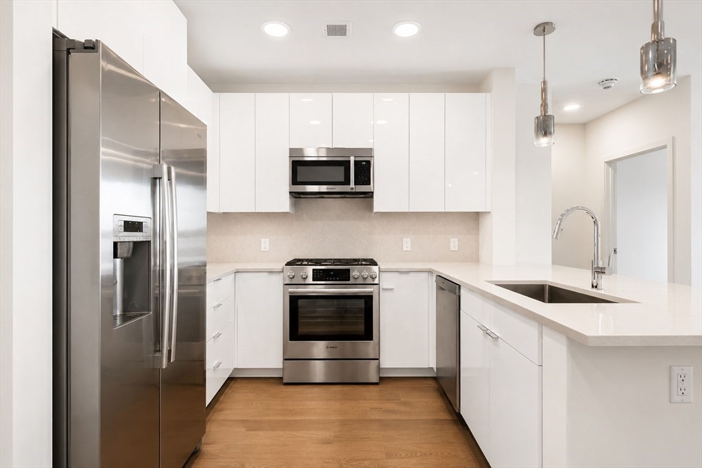 45 Lewis Street, Unit 312 Boston, MA 02128 - Photo 2 of 17 a kitchen with stainless steel appliances granite countertop a sink a stove a refrigerator and cabinets