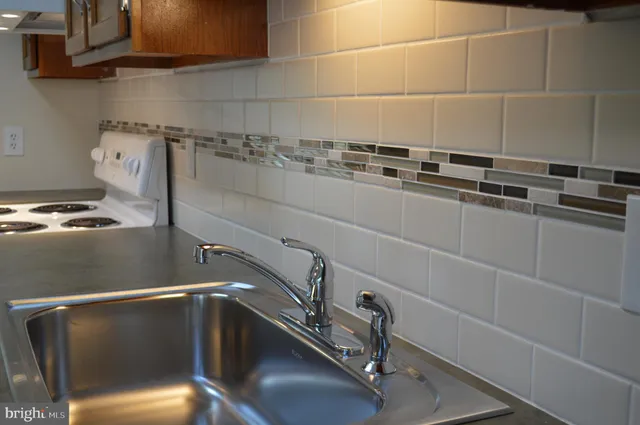 a kitchen with granite countertop a sink stove and cabinets