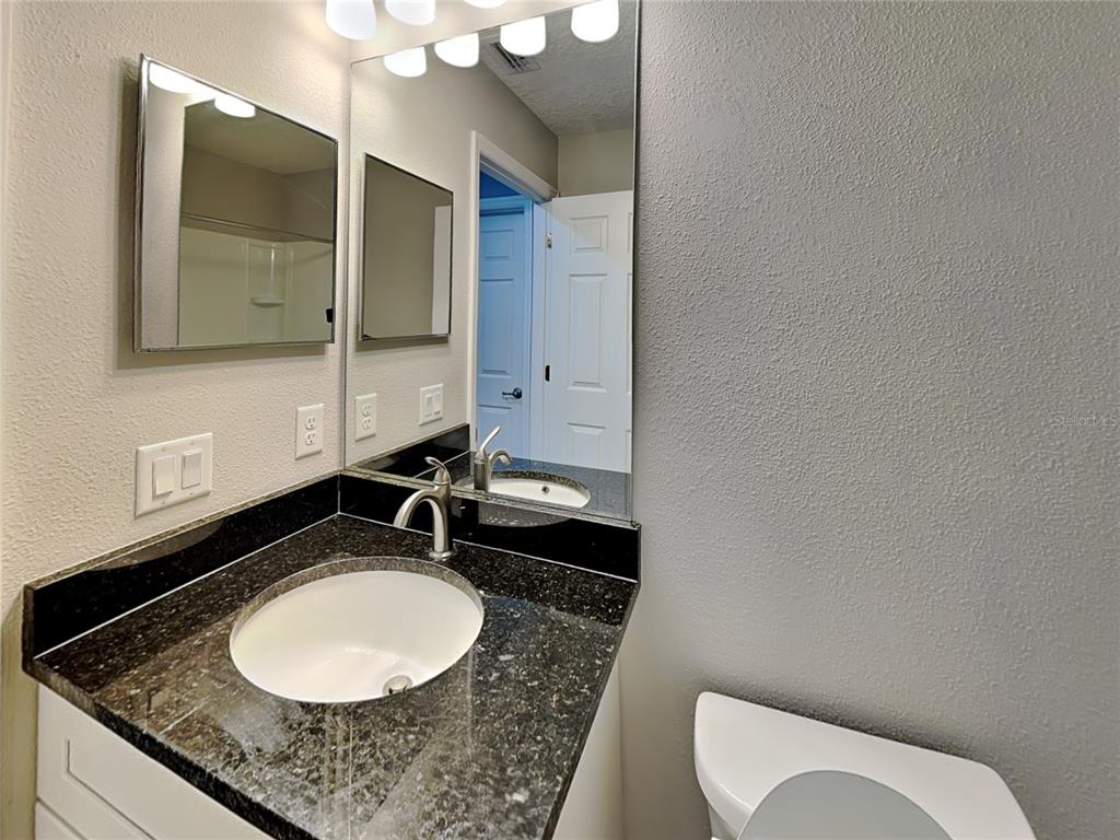 944 West Rum Place Dunnellon, FL 34434 - Photo 12 of 16 a bathroom with a granite countertop sink and a mirror