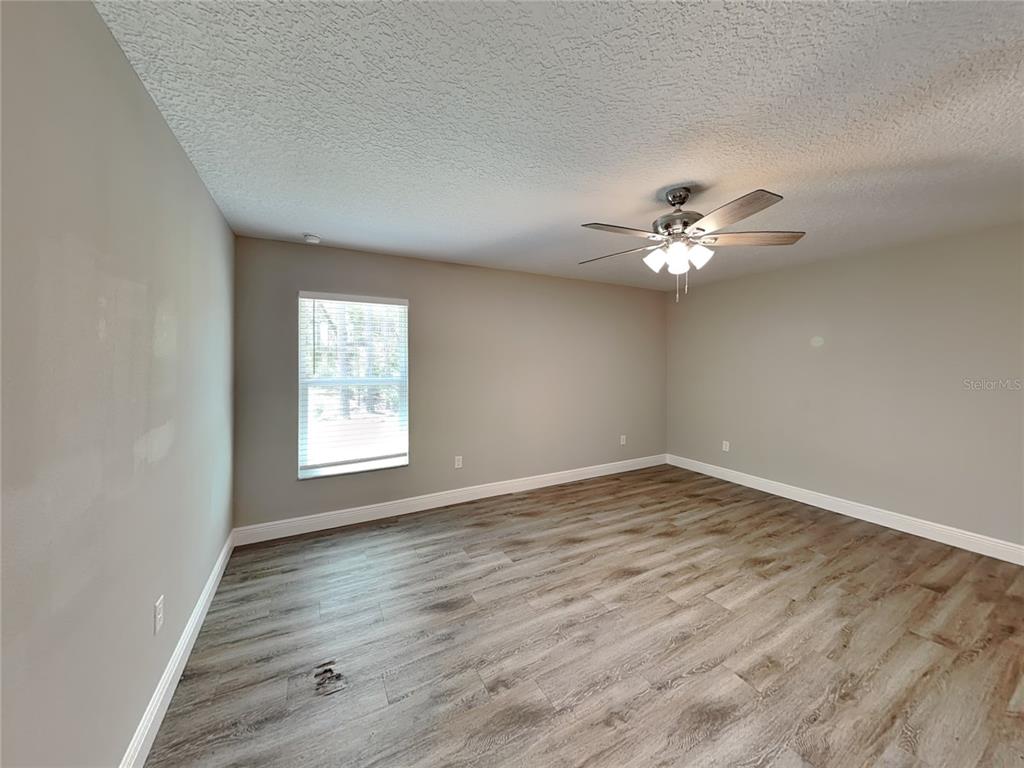 944 West Rum Place Dunnellon, FL 34434 - Photo 4 of 16 a view of an empty room with a window and wooden floor