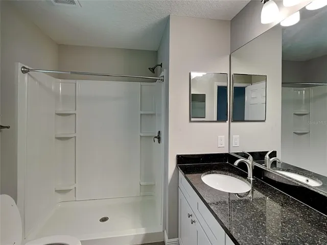 a bathroom with a granite countertop sink mirror and double