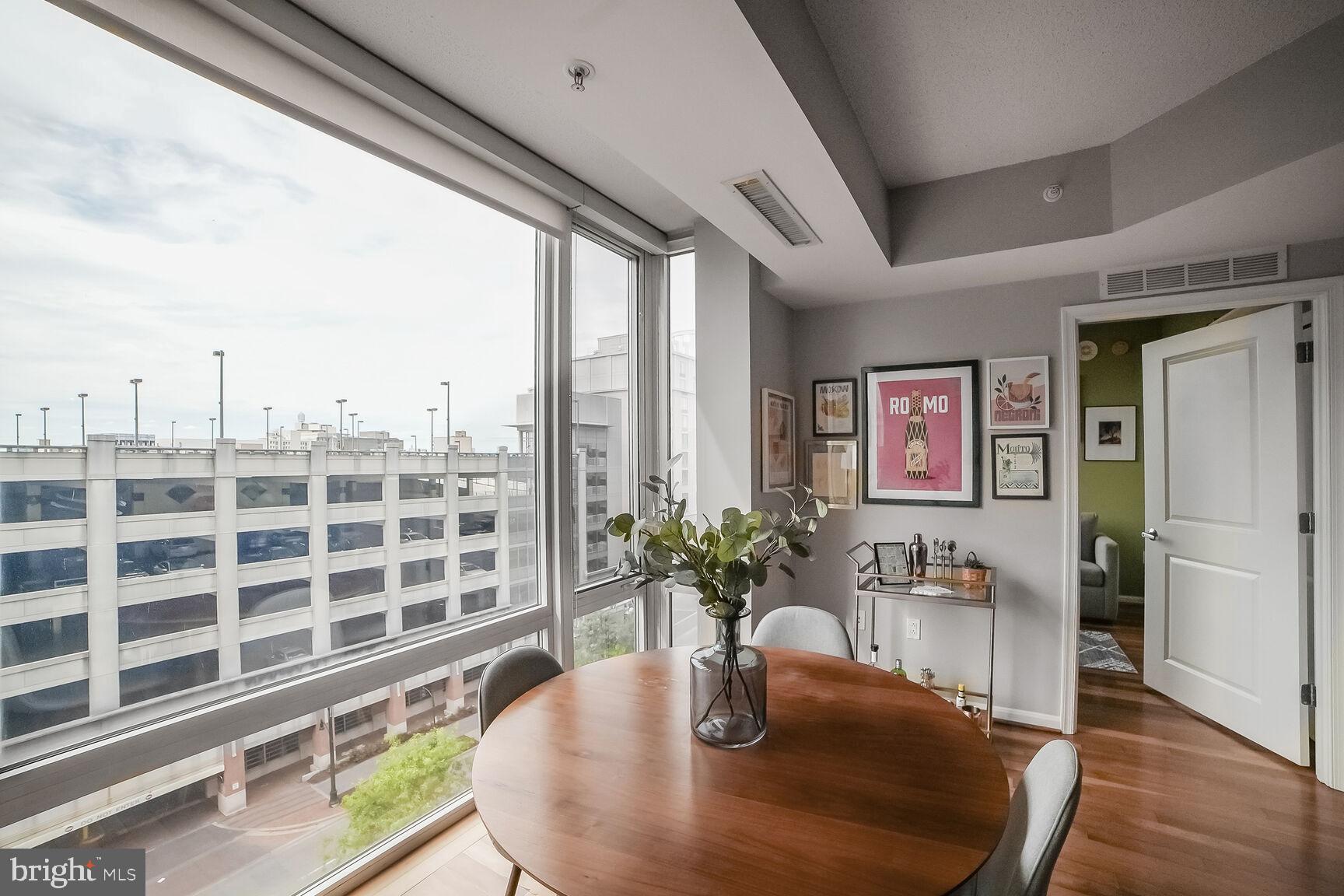 930 Wayne Avenue, Unit 708 Silver Spring, MD 20910 - Photo 13 of 35 a dining room with furniture a potted plant and wooden floor