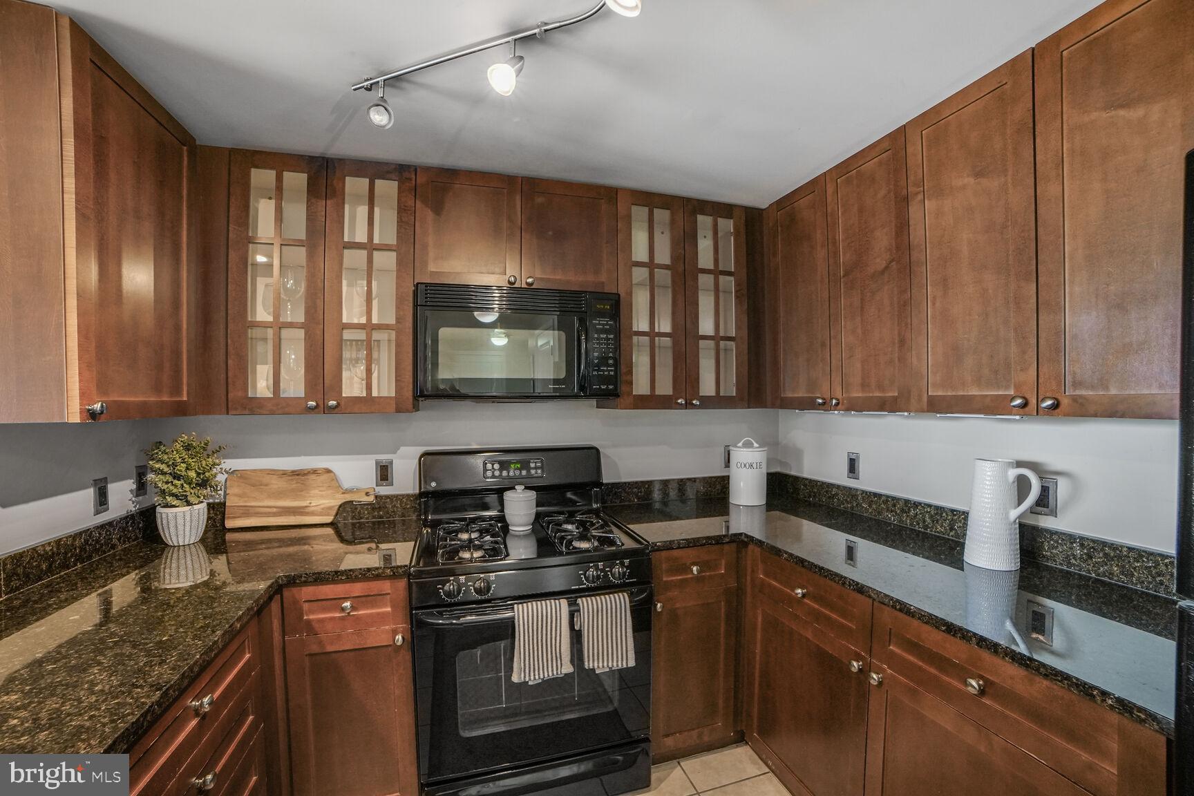 930 Wayne Avenue, Unit 708 Silver Spring, MD 20910 - Photo 16 of 35 a kitchen with stainless steel appliances granite countertop a stove a sink and a microwave