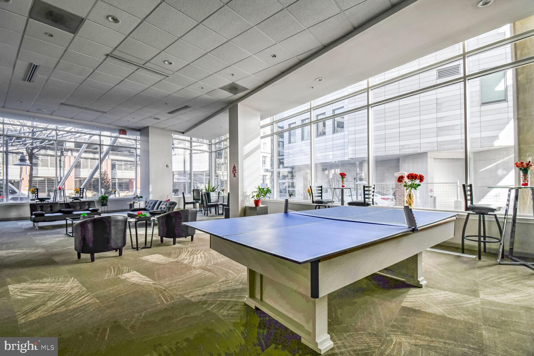 930 Wayne Avenue, Unit 708 Silver Spring, MD 20910 - Photo 29 of 35 a dining hall with stainless steel appliances granite countertop a table chairs and couches with wooden floor