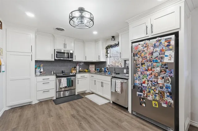a kitchen with stainless steel appliances a stove a sink and a refrigerator