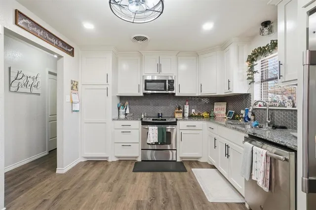 a kitchen with stainless steel appliances granite countertop a stove and a refrigerator
