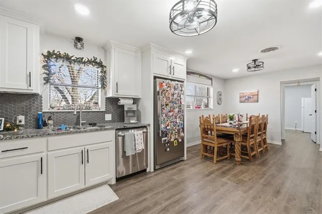 a kitchen with stainless steel appliances granite countertop a refrigerator and a stove top oven