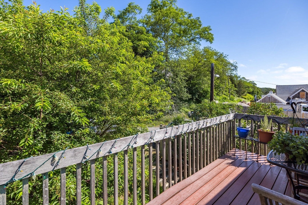4 South Highland Road, Unit C Truro, MA 02666 - Photo 17 of 21 a balcony with wooden floor and trees in the back