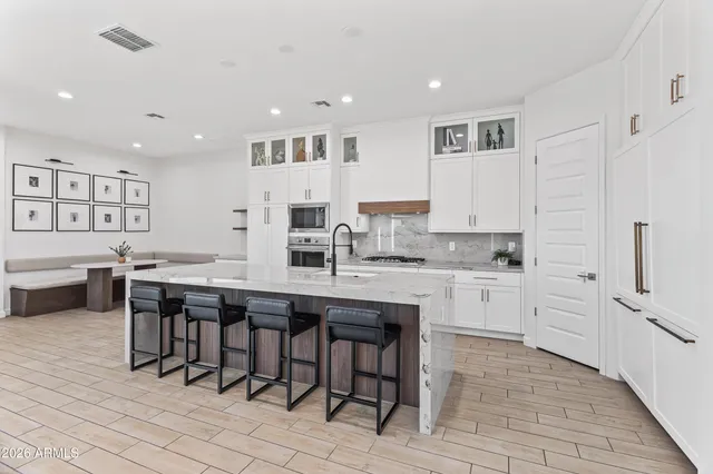 a living room with furniture kitchen view and a potted plant
