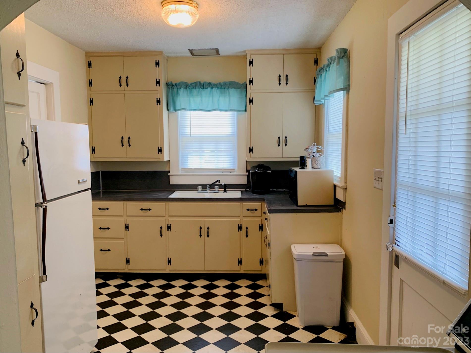 624 Main Street Hudson, NC 28638 - Photo 6 of 17 a kitchen with a refrigerator and white cabinets