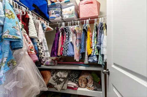 a view of walk in closet with clothes
