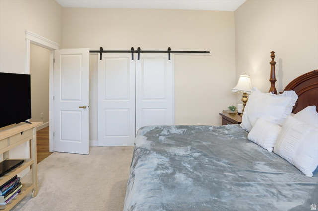 534 East Fish Hatchery Road Mantua, UT 84324 - Photo 36 of 87 Bedroom featuring a barn door and light colored carpet