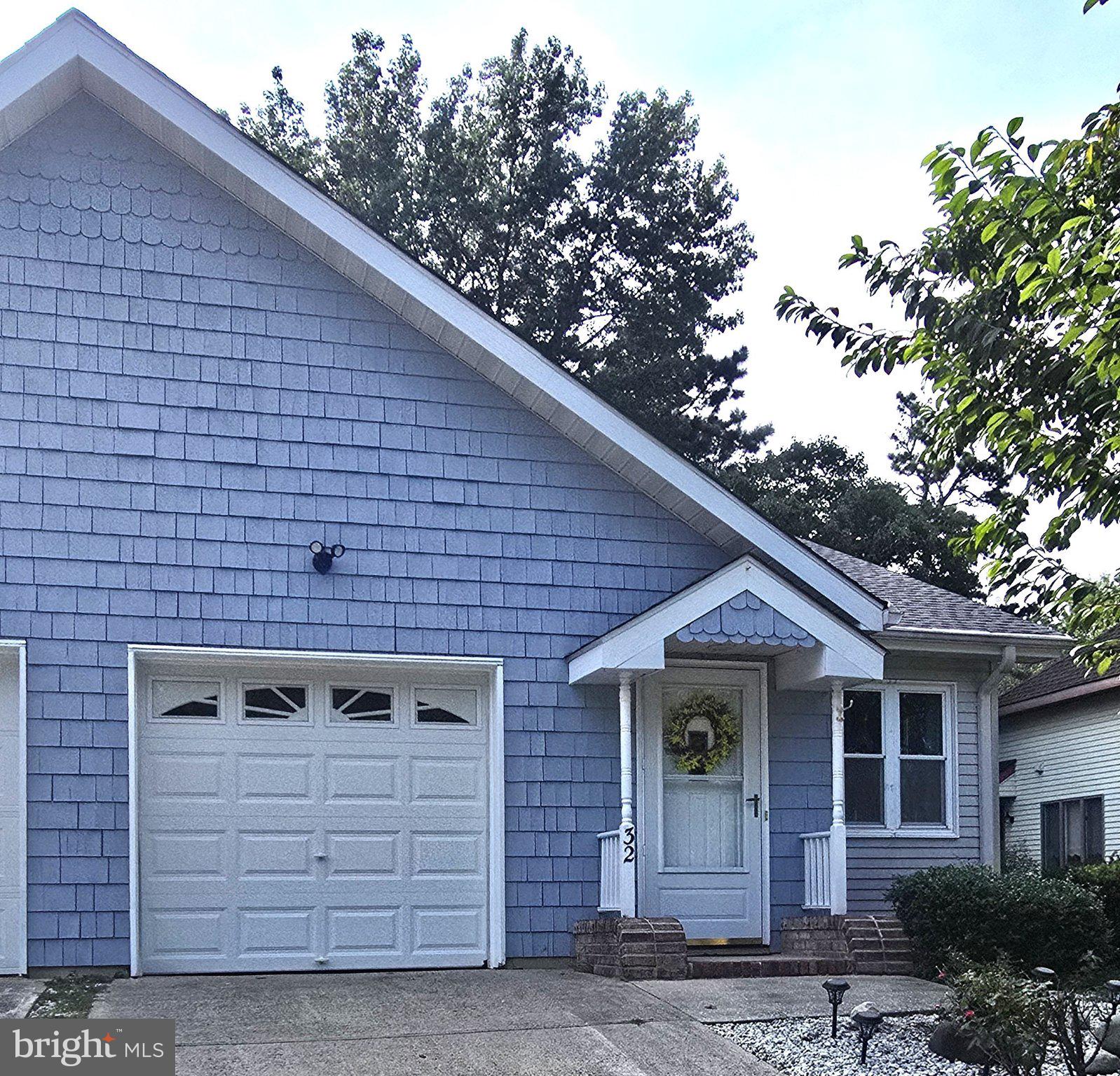 Charming blue home with inviting entrance.