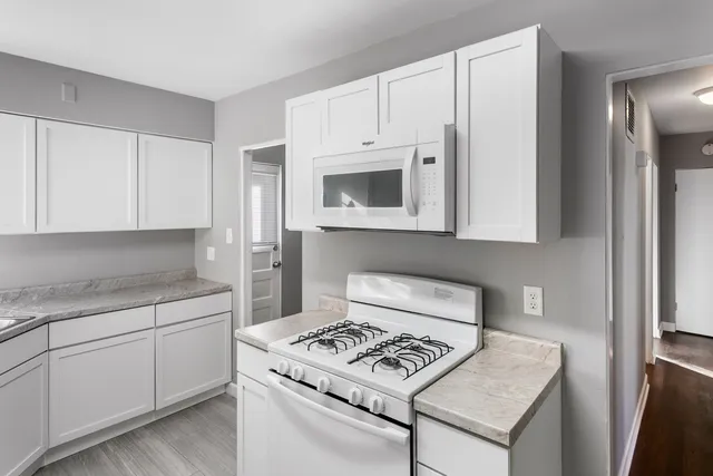 a kitchen with white cabinets and white appliances