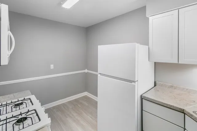 a white refrigerator freezer and a stove sitting inside of a kitchen