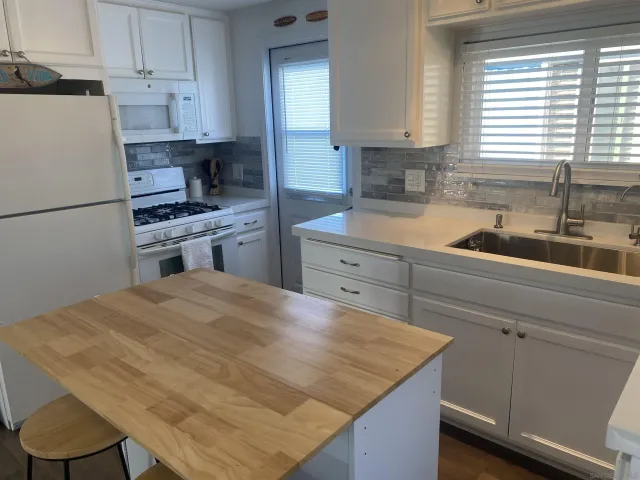 a kitchen with a stove a sink a refrigerator and cabinets