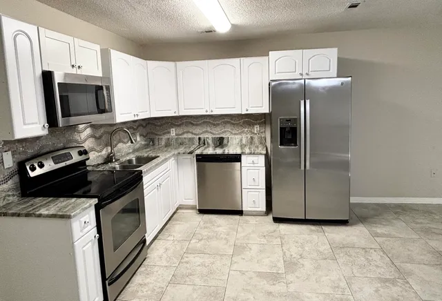 a kitchen with a stove sink and microwave