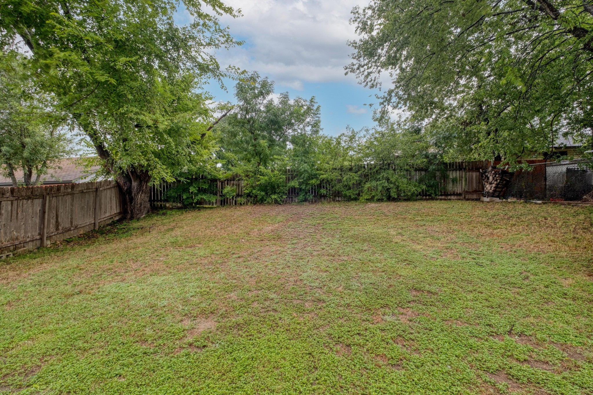12030 Rotherham Drive Austin, TX 78753 - Photo 18 of 19 Expansive backyard offers endless possibilities for play, gardening, or relaxing under mature shade trees.