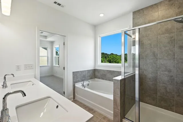 a bathroom with a tub sink and mirror
