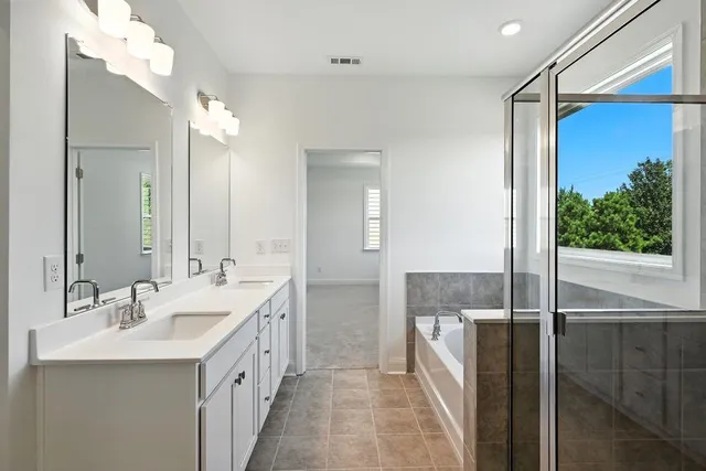 a bathroom with a double vanity sink mirror and shower