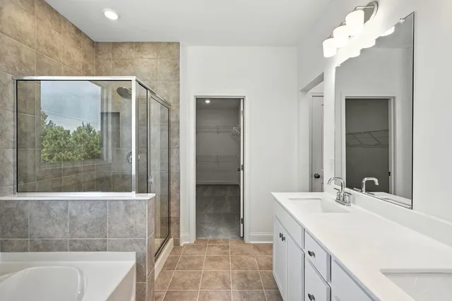 a bathroom with a double vanity sink mirror and bathtub