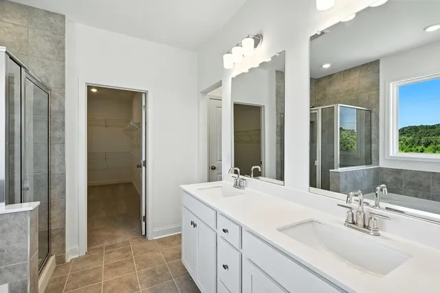 a bathroom with a double vanity sink mirror and shower