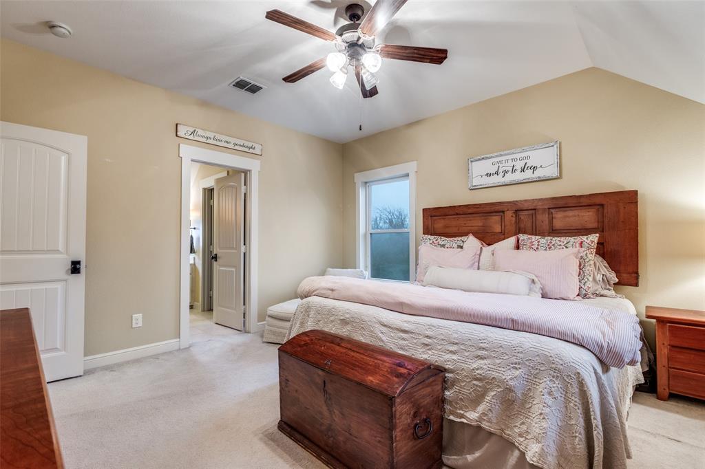 322 Red Maple Road Gunter, TX 75058 - Photo 22 of 33 a bedroom with a bed and a chandelier