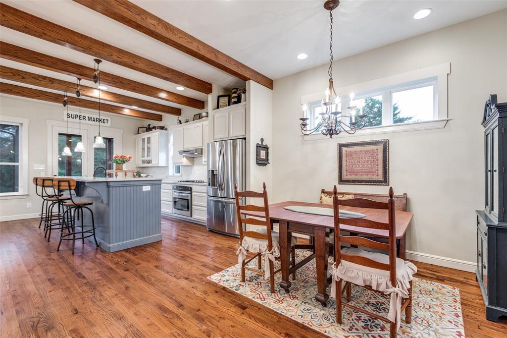 322 Red Maple Road Gunter, TX 75058 - Photo 7 of 33 a dining room with wooden floor a chandelier a wooden table and chairs