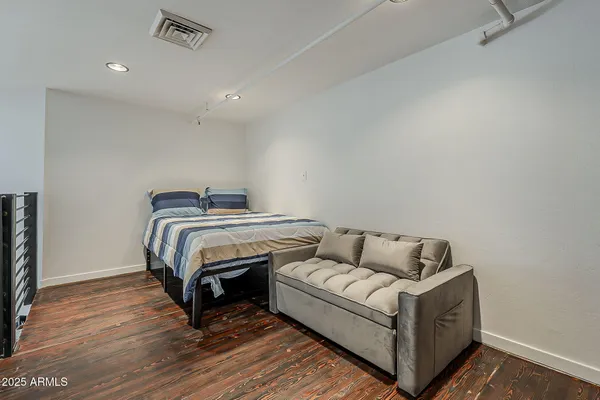 a bedroom with bed and wooden floor