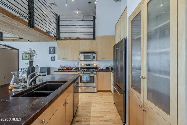 a kitchen with stainless steel appliances granite countertop a sink a stove and a refrigerator