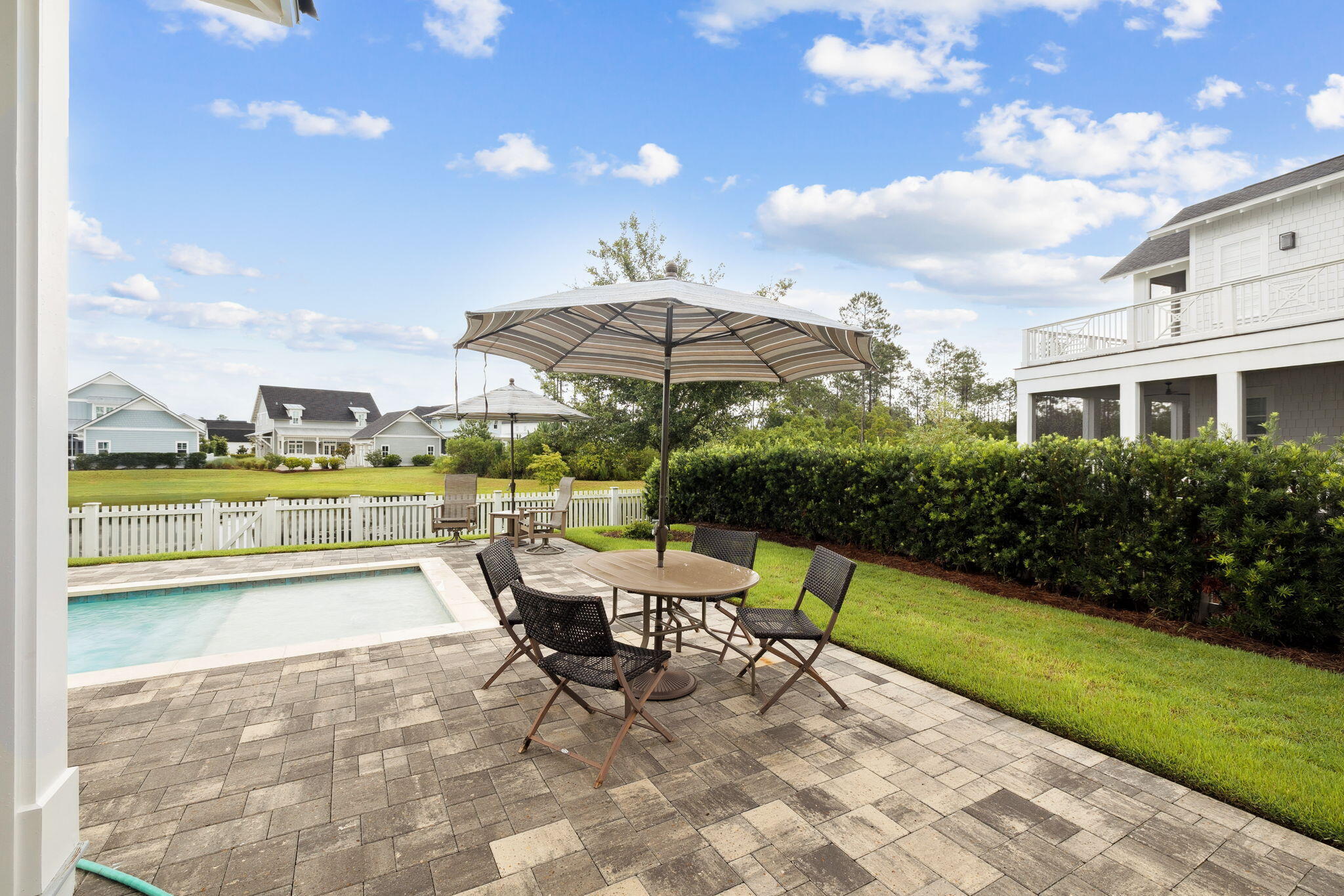 121 Needle Cast Ln Inlet Beach Inlet Beach, FL 32461 - Photo 19 of 63 a view of a patio with a dining table and chairs with an umbrella