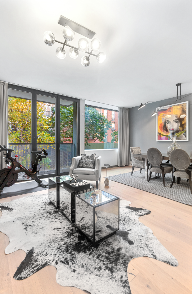 277 East 7th Street, Unit 2 Manhattan, NY 10009 - Photo 2 of 11 a living room with furniture a large window and flat screen tv
