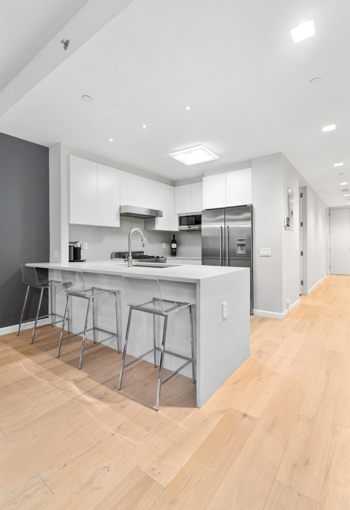 277 East 7th Street, Unit 2 Manhattan, NY 10009 - Photo 5 of 11 a kitchen with stainless steel appliances kitchen island a refrigerator sink and cabinets