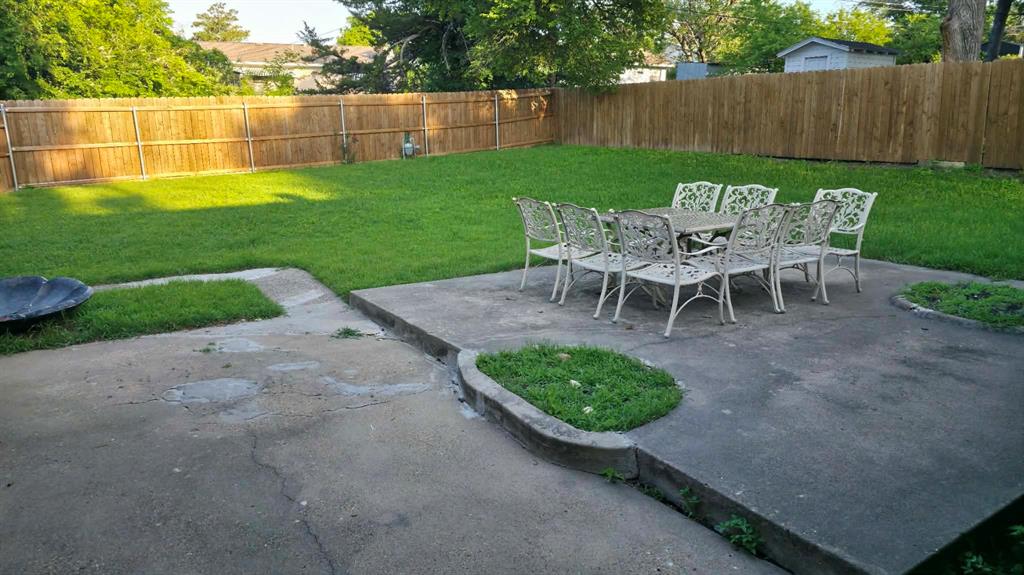 5722 Old Ox Road Dallas, TX 75241 - Photo 10 of 10 a view of a backyard with table and chairs and wooden fence