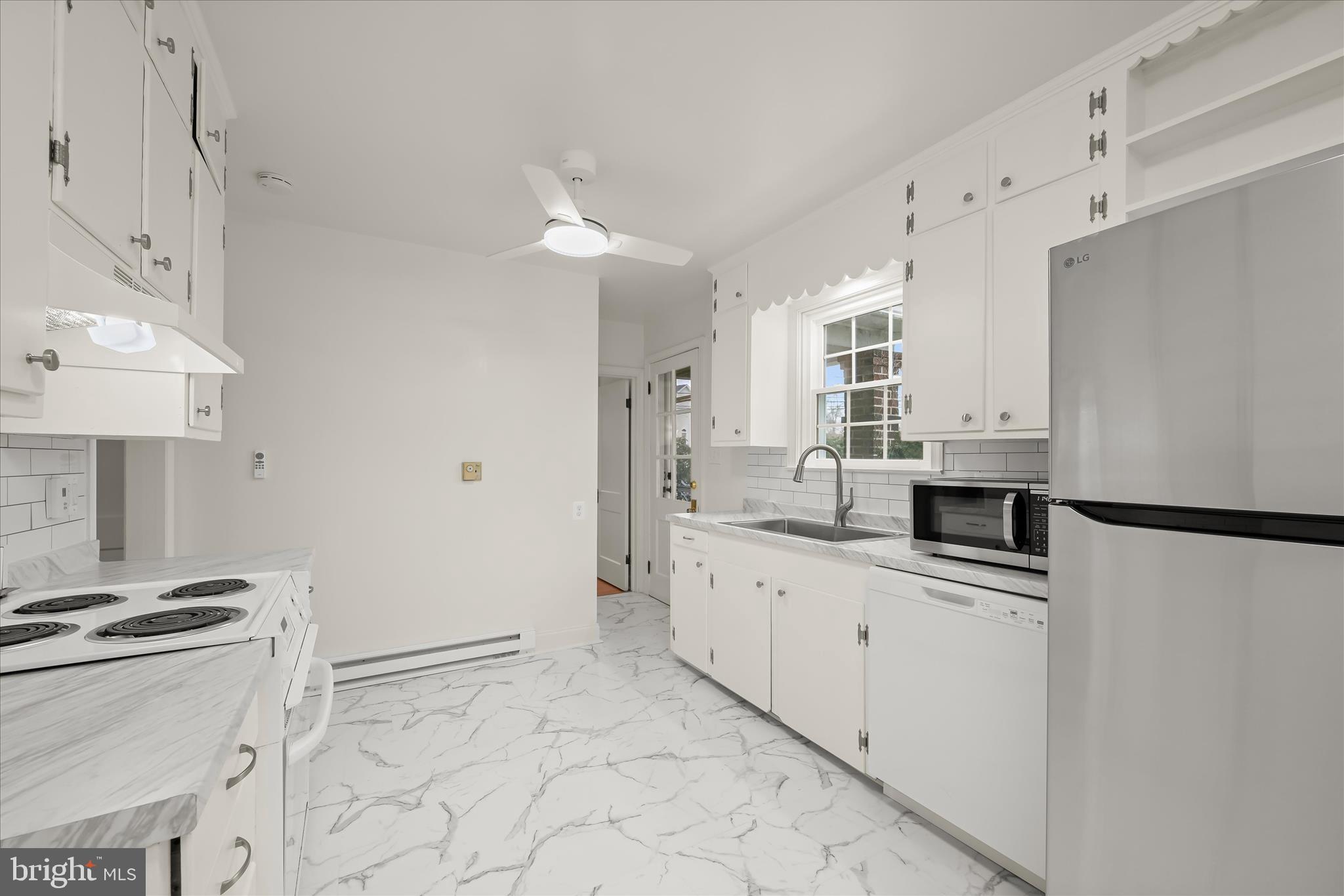 1631 Shookstown Road Frederick, MD 21702 - Photo 20 of 69 a kitchen with granite countertop a sink a stove a refrigerator and white cabinets