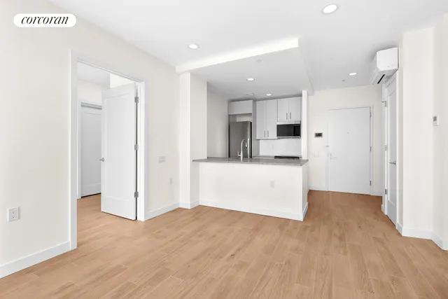 a view of kitchen with refrigerator cabinets and wooden floor