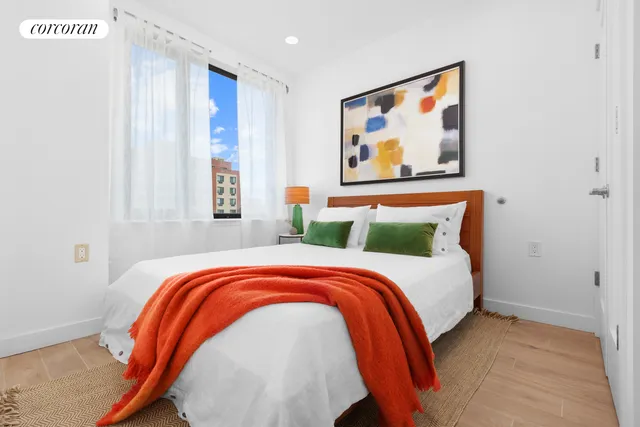 a bedroom with a bed and a painting on the wall