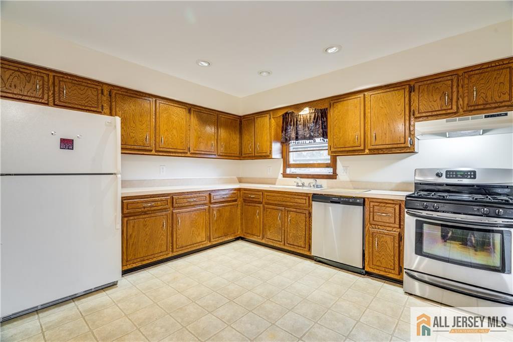 106 Farragut Avenue Middlesex, NJ 08846 - Photo 7 of 25 a kitchen with granite countertop a stove top oven sink and cabinets