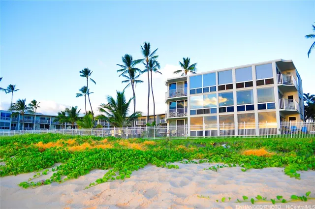 a front view of a building with a garden and plants