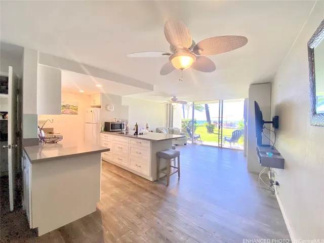 a living room with stainless steel appliances furniture and a chandelier