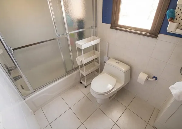 a white toilet sitting next to a bathroom sink and a shower